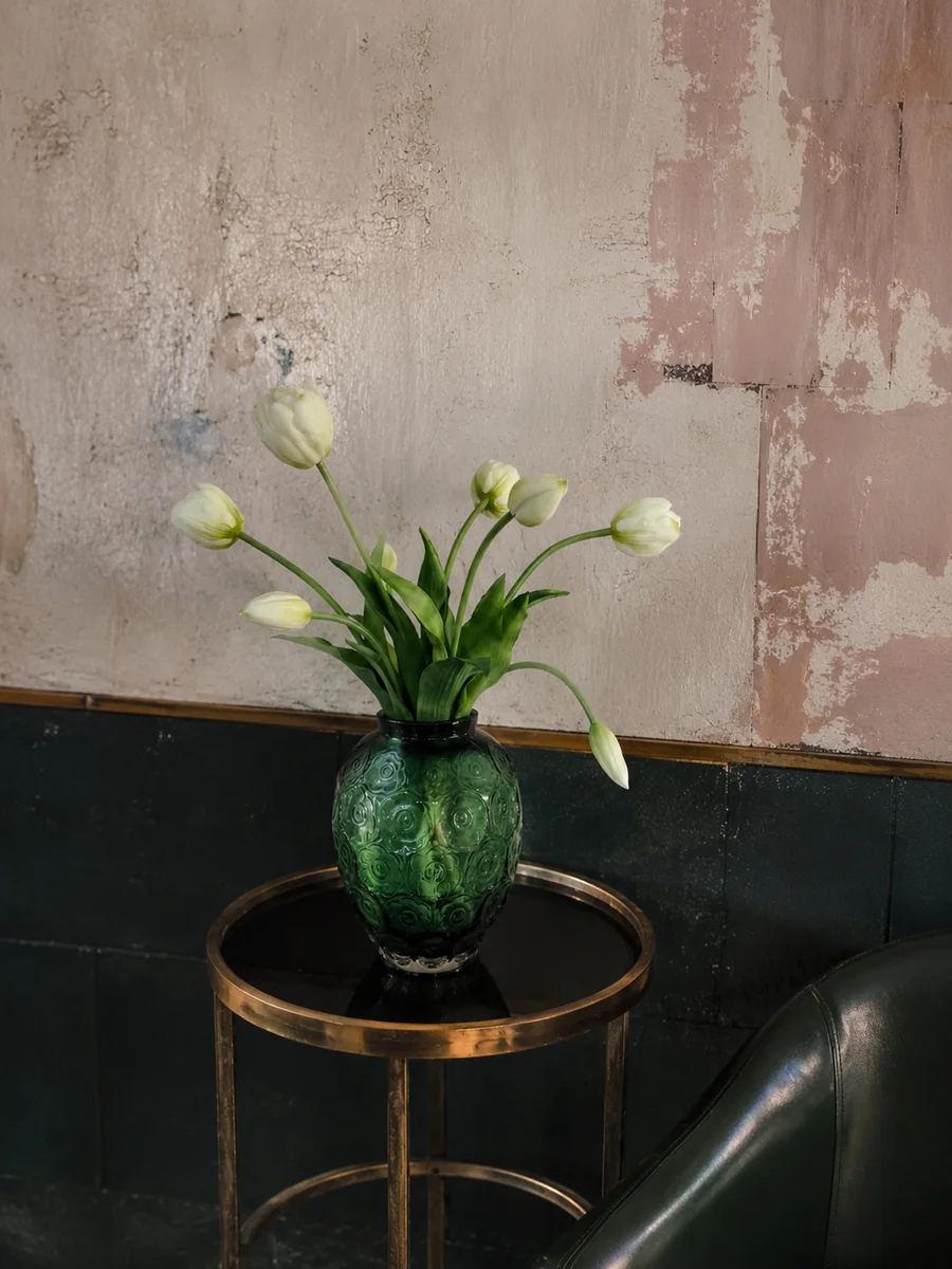 White artificial tulips arranged in a deep green handcrafted glass vessel, PO003