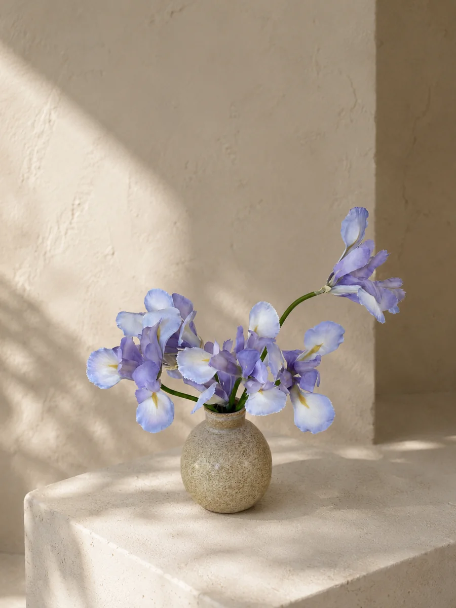 Delicate blue artificial iris arrangement in a rounded ceramic vessel, PO009